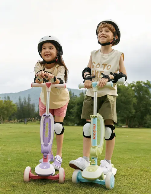 Two children riding mideer scooters outdoors