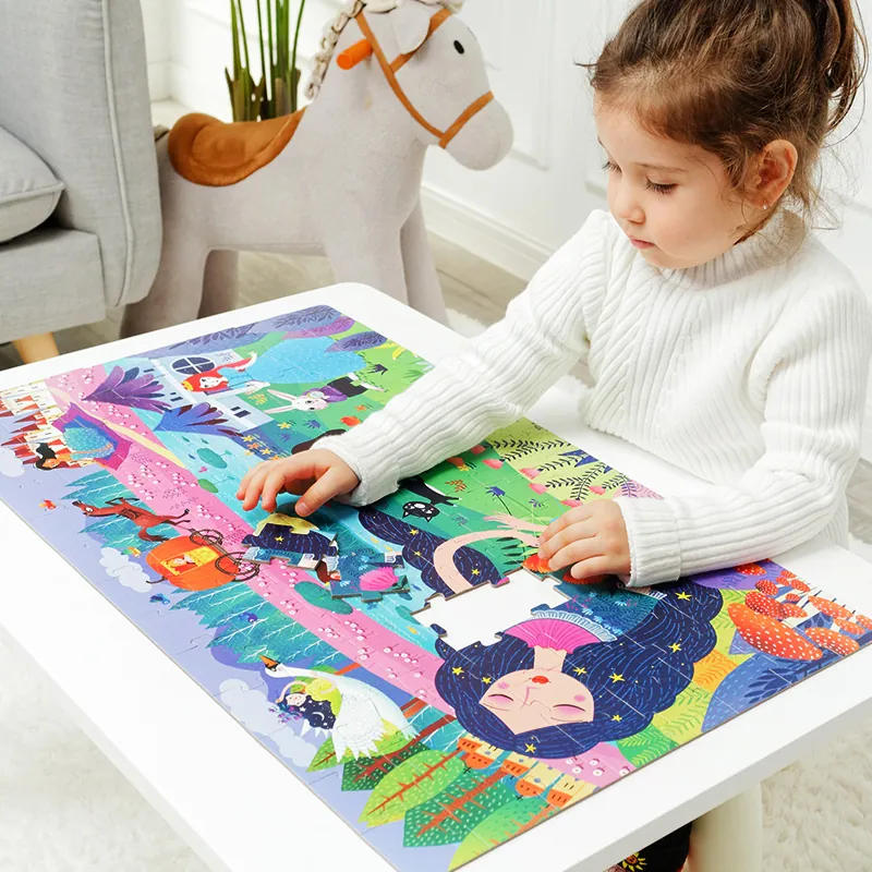 A young girl working on a large mideer floor puzzle
